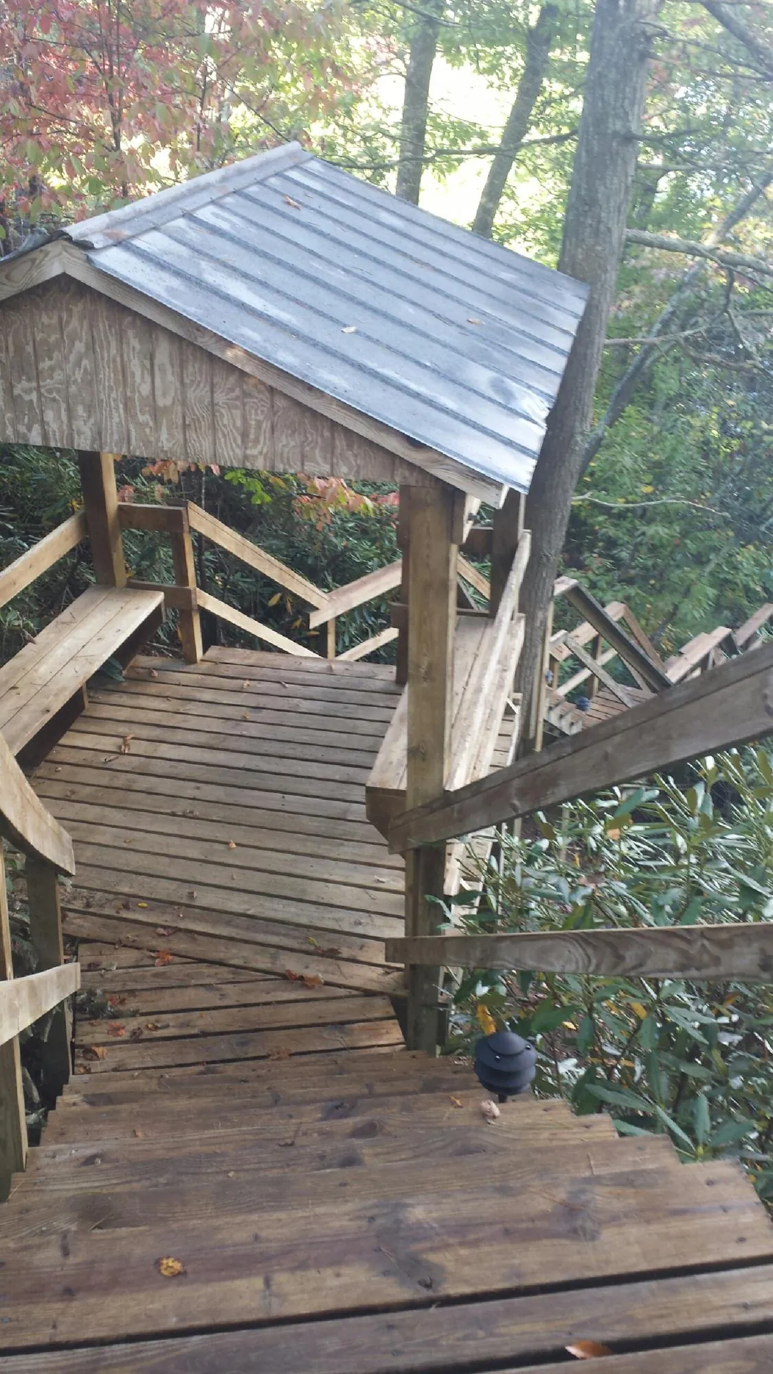 Metal roofed shelter over wooden steps on a wooded walkway — Skylight Repair & Installation work by our crew in Williamsport